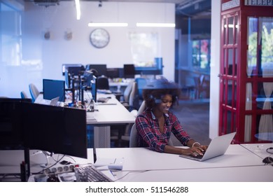 portrait of a young successful African American beautiful woman who enjoys spending a quality and joyful time while working in a large modern office - Shutterstock ID 511546288