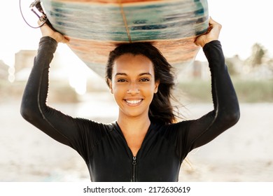 Portrait Of Young Surfer Woman On The Beach Holding Her Surfboard