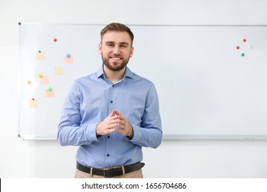 Portrait Of Young Teacher Near Whiteboard In Classroom