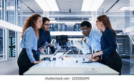 Portrait of a Young Team of Multicultural Engineers Use Computers, Insert a Circuit Board, Analyze and Discuss How a Futuristic Robot Dog Works. High Tech Research Laboratory with Modern Equipment. - Powered by Shutterstock