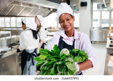 portrait young teen girl cook student. Cooking class. culinary classroom. happy young african woman students holding fresh vegetables for cooking in cooking school.  - Shutterstock ID 2166937995