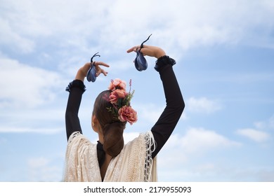 Portrait Of Young Teenage Girl In Black Dance Dress, White Shawl And Pink Carnations In Her Hair, Dancing Flamenco With Castanets In Her Hands. Concept Of Flamenco, Dance, Art, Typical Spanish Dance.