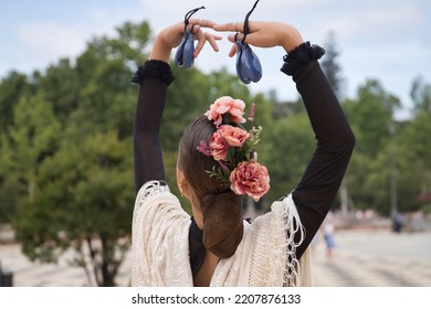 Portrait Of Young Teenage Girl In Black Dance Dress, White Shawl And Pink Carnations In Her Hair, Dancing Flamenco With Castanets In Her Hands. Concept Of Flamenco, Dance, Art, Typical Spanish Dance.