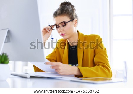 Portrait of a young tired businesswoman using laptop and working