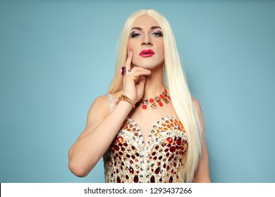 Portrait of young transgender woman in bright costume on color background