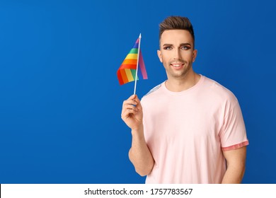 Portrait Of Young Transgender Woman With Flag Of LGBT On Color Background