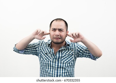 Portrait of young unhappy, stressed man covering his ears, looking up don't want to hear anything isolated white background.  - Shutterstock ID 670332355