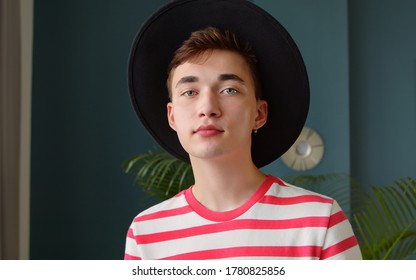 Portrait of a young unusual man in a hat. Hipster guy student designer looking at the camera and smiling. Beautiful stylish people concept.