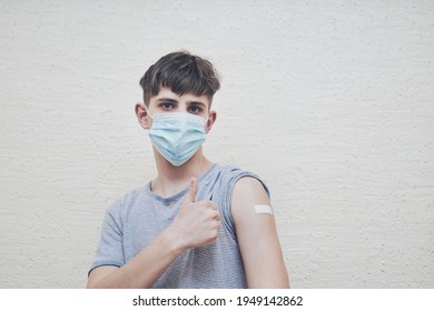 Portrait Of Young Vaccinated Man With Coronavirus Vaccine, Plaster On His Shoulder