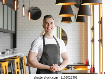 Portrait Of Young Waiter In Uniform At Cafe