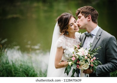 Portrait of young wedding couple kissing at nature. Newlyweds.