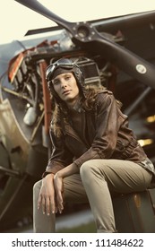 Portrait Of Young Woman Airplane Pilot. Airplane On The Background