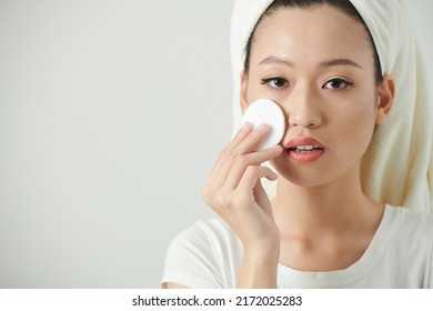 Portrait Of Young Woman Applying Face Toner With Cotton Pad To Restore Skin PH Level