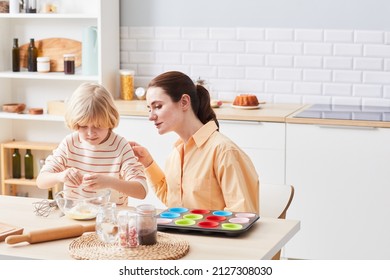 Portrait Of Young Woman Baking Cupcakes With Cute Little Boy Helping Mom In Kitchen, Copy Space