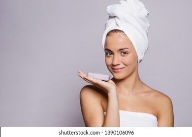 A portrait of young woman with a bar of soap in a studio, beauty and skin care.