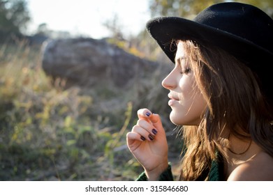 Portrait Of Young Woman In Black Hat With Closed Eyes. Sideview Of Pretty Girl Enjoying Autumn Sunlight On Blurred Outdoor Background.