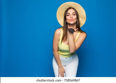 Portrait of a young woman blowing kiss at camera isolated on the blue background
