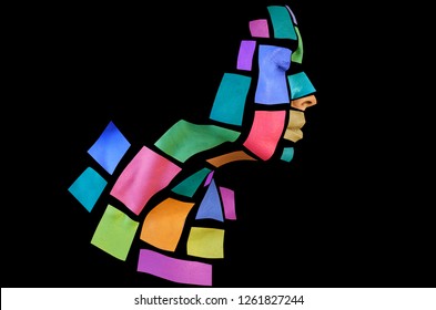 Portrait of a young woman with bold glowing makeup posing in the studio. Shape of colored squares on woman face. Isolated on black background.