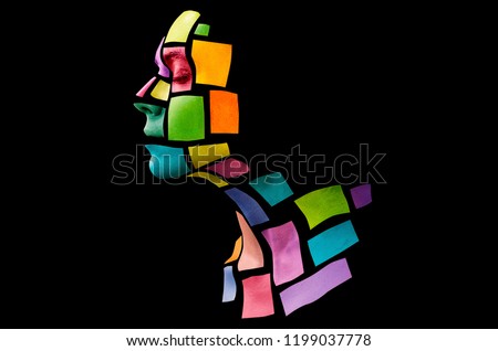 Portrait of a young woman with bold glowing makeup posing in the studio. Shape of colored squares on female face. Isolated on black background.