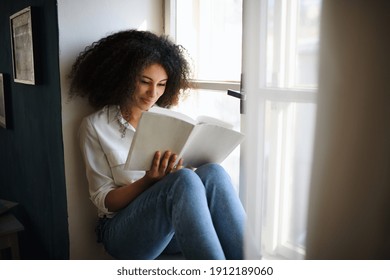 Portrait of young woman with book indoors at home, reading. - Shutterstock ID 1912189060