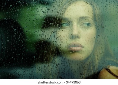 Portrait Of A Young Woman In The Car During The Rain