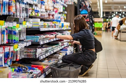 Portrait of young woman choosing school stationery in supermarket. shopping - Powered by Shutterstock