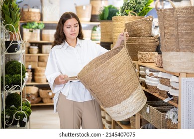 Portrait Of Young Woman Choosing Storage Basket At Store Of Household Goods