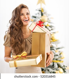 Portrait Of Young Woman With Christmas Present Boxes In Front Of Christmas Tree