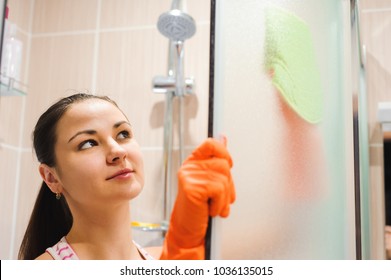 Portrait Of Young Woman Cleaning Shower Door