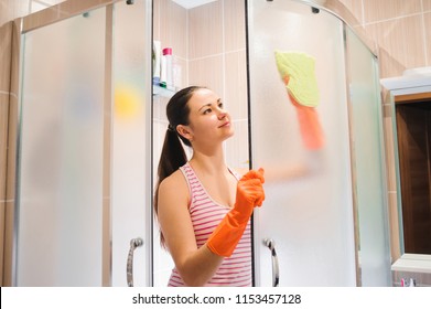 Portrait Of Young Woman Cleaning Shower Door