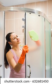 Portrait Of Young Woman Cleaning Shower Door