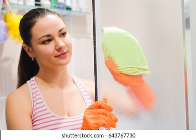 Portrait Of Young Woman Cleaning Shower Door