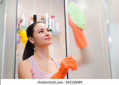 Portrait Of Young Woman Cleaning Shower Door