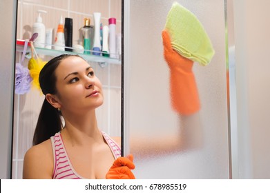 Portrait Of Young Woman Cleaning Shower Door