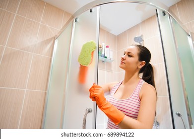 Portrait Of Young Woman Cleaning Shower Door