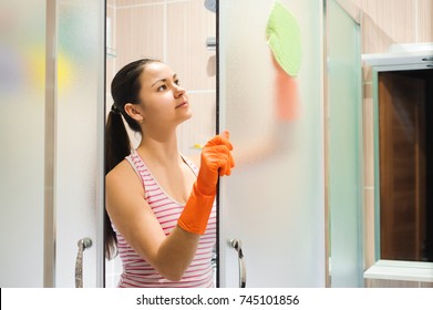 Portrait Of Young Woman Cleaning Shower Door