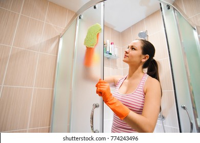 Portrait Of Young Woman Cleaning Shower Door