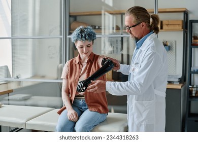 Portrait of young woman with colored hair smiling during prosthetic fitting in orthology clinic, copy space - Powered by Shutterstock