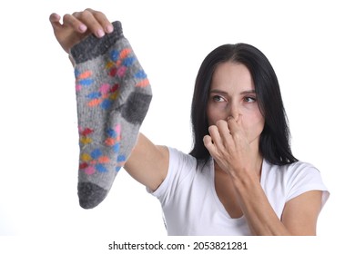 Portrait of young woman covering nose and holding sock in hand closeup