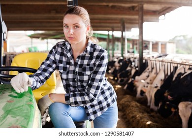 Portrait of young woman dairy farm owner working on tractor in cowshed - Powered by Shutterstock