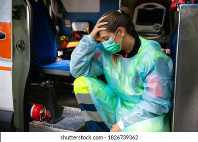 Portrait of a young woman doctor sitting on the ambulance resting exhausted where a first aid intervention during the Covid-19 pandemic, Coronavirus wearing a face mask - Rescue concept - Shutterstock ID 1826739362