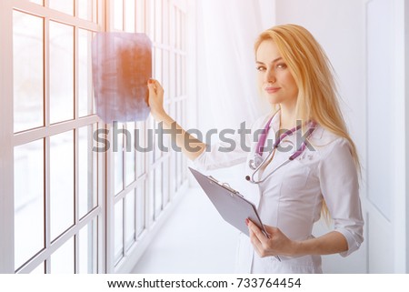 Portrait of young woman doctor with stethoscope and x-ray.