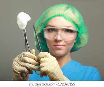 Portrait of young woman doctor surgeon (or nurse) with scalpel