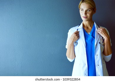 Portrait of young woman doctor with white coat standing in hospital. - Shutterstock ID 1039322854