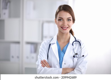 Portrait Of Young Woman Doctor With White Coat Standing  In Hospital