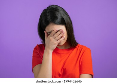 Portrait of young woman doing facepalm gesture, like no, I forgot. Unhappy woman feeling sorrow, regret, drama, failure. She isolated on violet wall. High quality photo