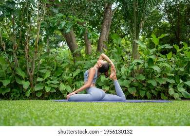 Portrait of a young woman doing yoga in the garden for a workout. Concept of lifestyle fitness and healthy. Asian women are practicing yoga in the park. - Powered by Shutterstock