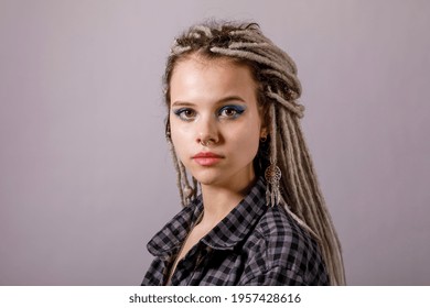Portrait of a young woman with dreadlocks and piercings. Modern hairstyle style.