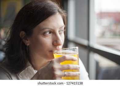 Portrait Of A Young Woman Drinking A Pint Of Hard Cider.