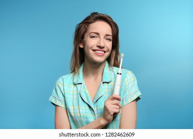 Portrait Of Young Woman With Electric Toothbrush On Color Background